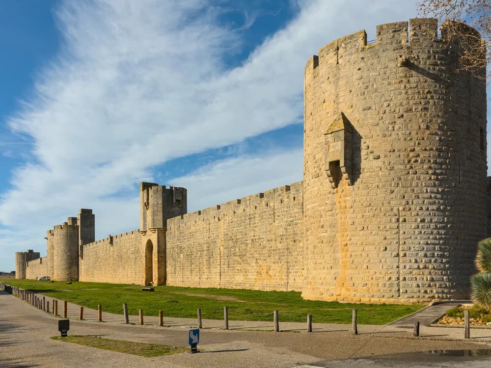 The medieval ramparts and Tour de Constance of Aigues-Mortes rising from the Camargue marshes — Saint Louis's 13th-century Crusade port and Huguenot prison, with nearly a mile of walkable medieval walls