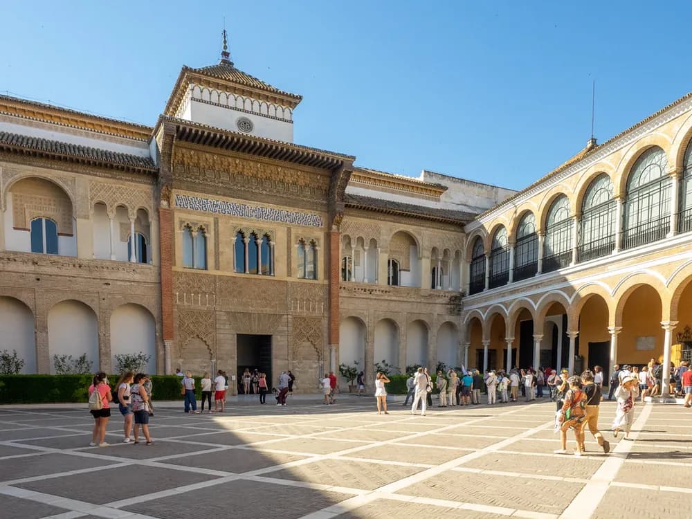 The courtyard of the Alcázar of Seville with its Mudéjar arches and reflecting pool, surrounded by orange trees