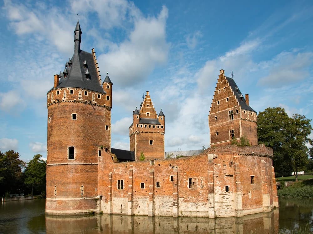Beersel Castle's three round towers reflected in the surrounding moat, Flemish Brabant, Belgium