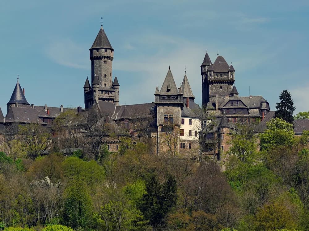 Braunfels Castle rising above the half-timbered town of Braunfels in Hesse — the fairy-tale silhouette of clustered towers and steeply pitched roofs, still owned by the Solms-Braunfels family