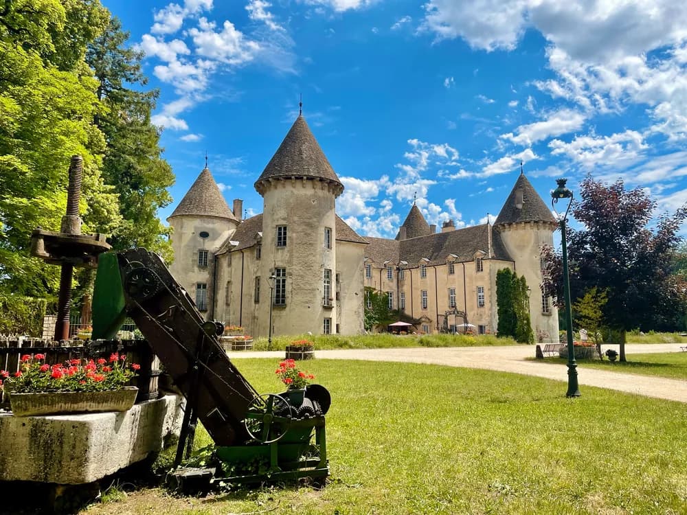 Château de Savigny-lès-Beaune in Burgundy — medieval towers with military aircraft in the grounds, combining a 14th-century castle with one of Europe's largest private plane collections