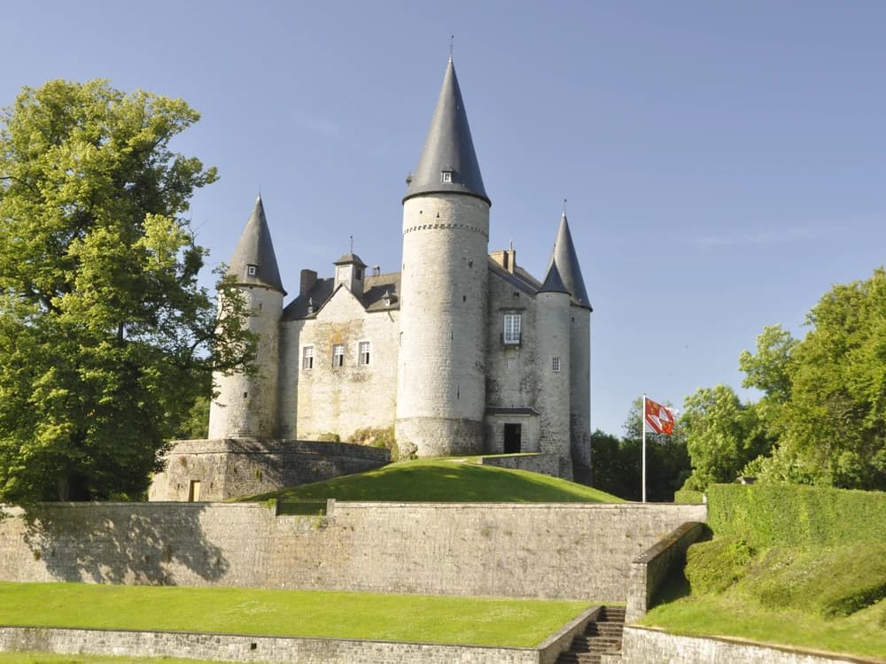 Château de Vêves with its five pointed towers rising above the Ardennes forest near Dinant, Belgium