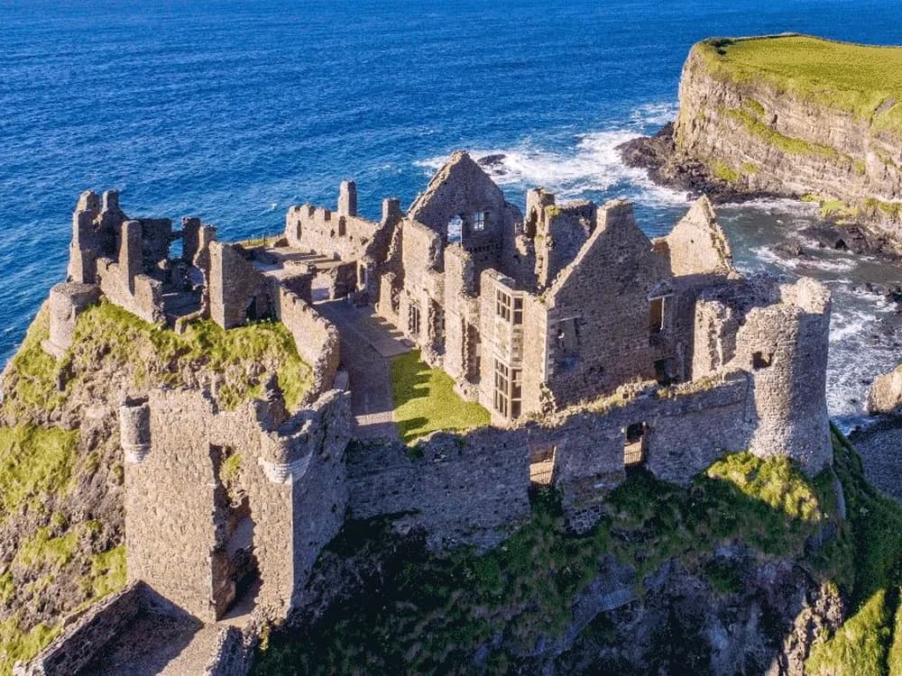 Dunluce Castle ruins on the edge of a basalt sea stack above the Atlantic in Northern Ireland