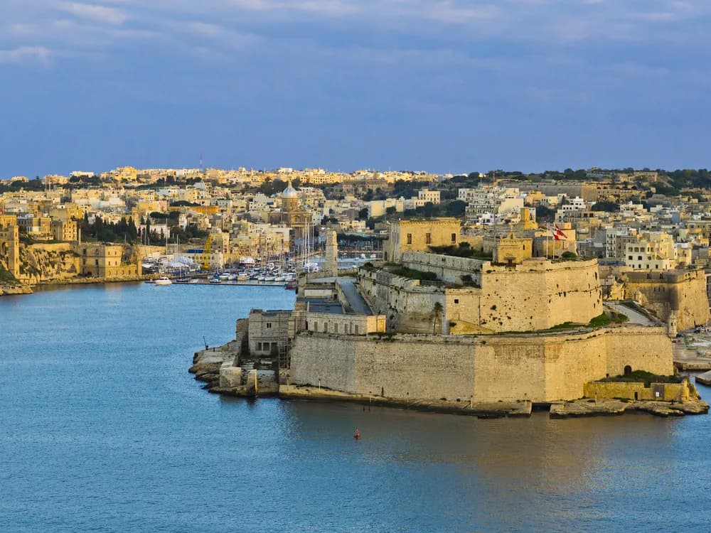 Fort St. Angelo's bastions rising above Grand Harbour in Birgu, Malta, with Valletta visible across the water