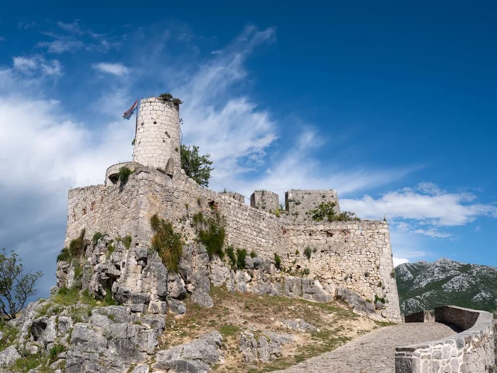 Klis Fortress on its narrow ridge above Split with the Adriatic Sea and Dalmatian islands visible beyond, Croatia