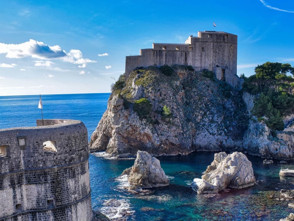 Lovrijenac Fortress on its sea cliff above the Adriatic, with Dubrovnik's Old Town walls visible behind