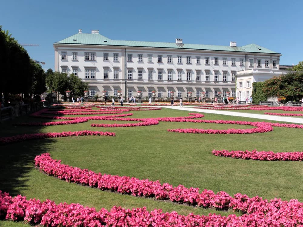 Mirabell Palace and the Mirabellgarten Baroque parterre in Salzburg, with Hohensalzburg Fortress visible on the Festungsberg across the Salzach