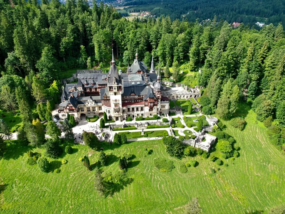 Peleș Castle in Sinaia — Neo-Renaissance towers and painted gables rising from Carpathian mountain forest