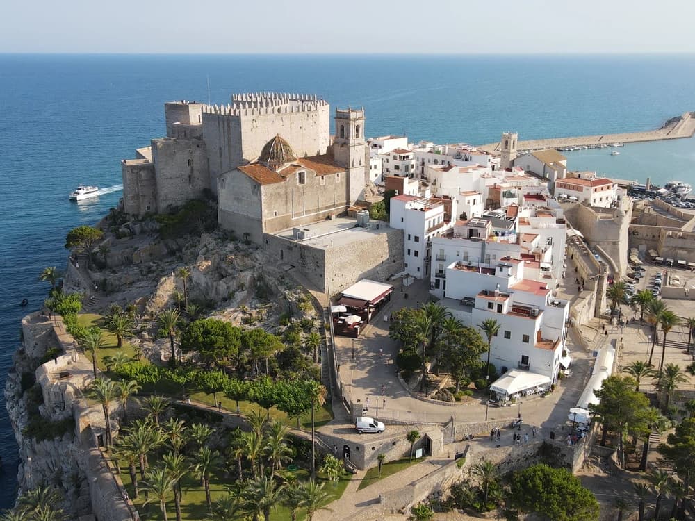 Peñíscola Castle's Knights Templar walls rising from the golden limestone promontory above the whitewashed old town, with the blue Mediterranean stretching to the horizon