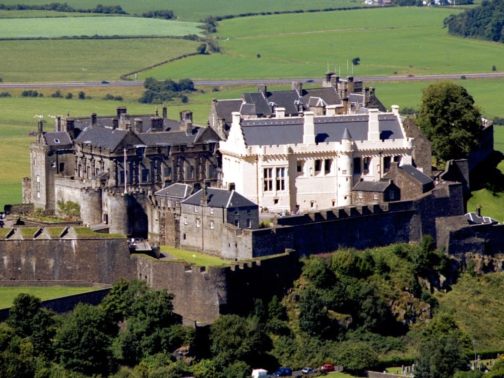 Stirling Castle on its volcanic rock above the Forth Valley, with the Wallace Monument visible in the distance