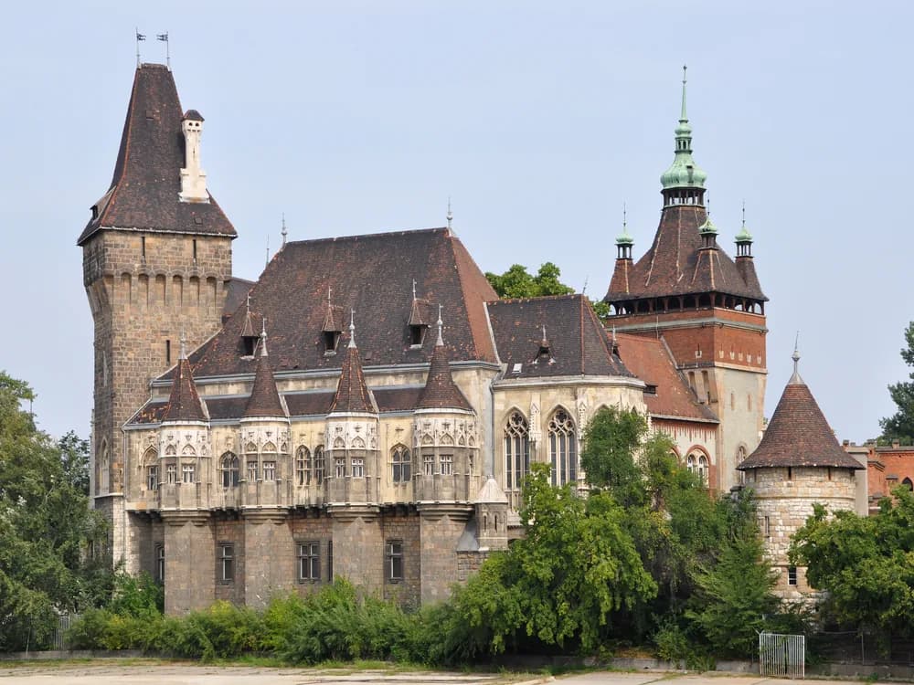 Vajdahunyad Castle's eclectic towers reflected in the pond of City Park, Budapest