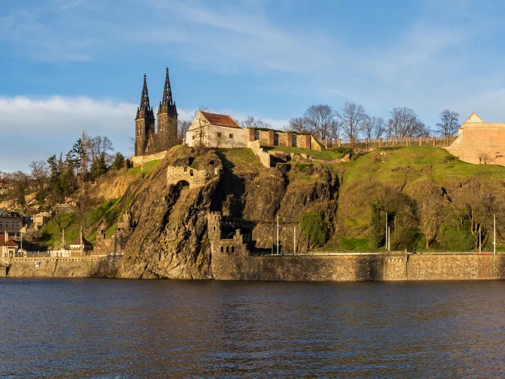 Vyšehrad's Baroque brick ramparts above the Vltava river in Prague, with the Basilica of St Peter and Paul's towers visible behind