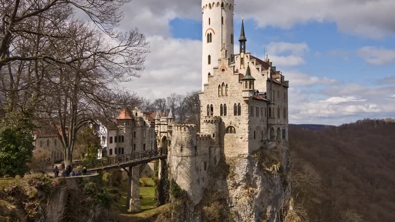 Neuschwanstein Castle rising from the Bavarian forest in autumn — Germany's most famous castle