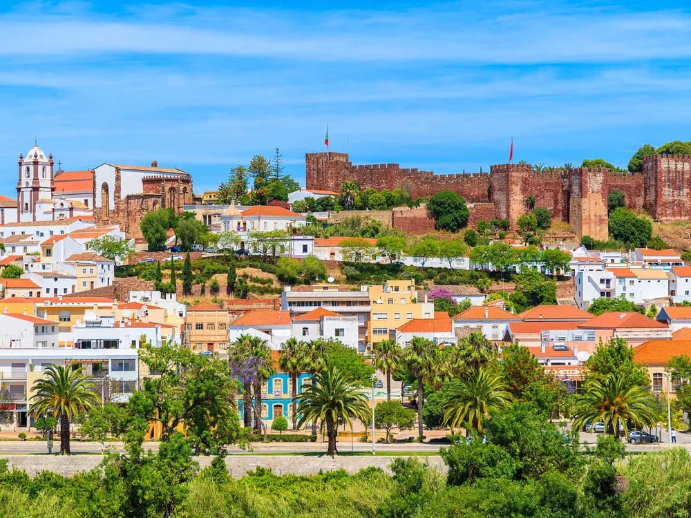 Silves Castle red sandstone walls above the orange groves of the Algarve, Portugal