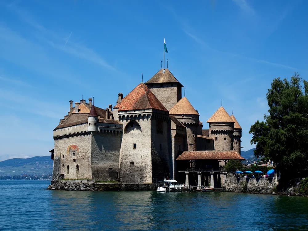 Château de Chillon rising from Lake Geneva with the Alps behind it on a clear afternoon