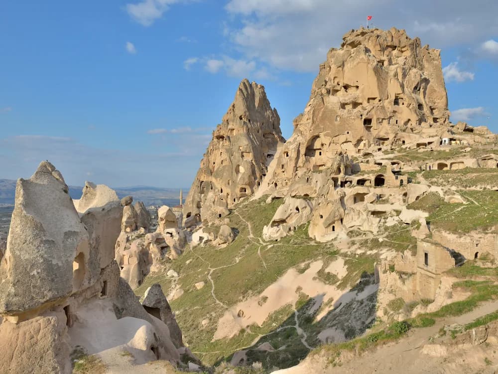 Uchisar rock castle rising above the fairy chimneys of Cappadocia at dawn