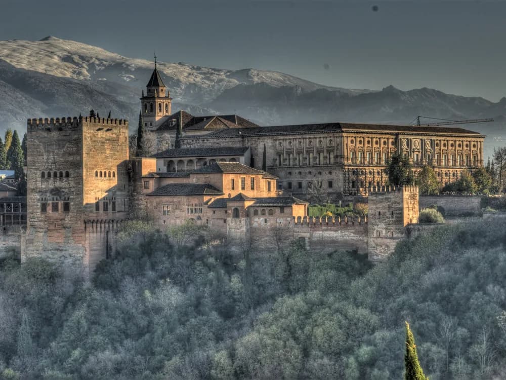 The Alhambra palace complex rising above Granada with the Sierra Nevada behind
