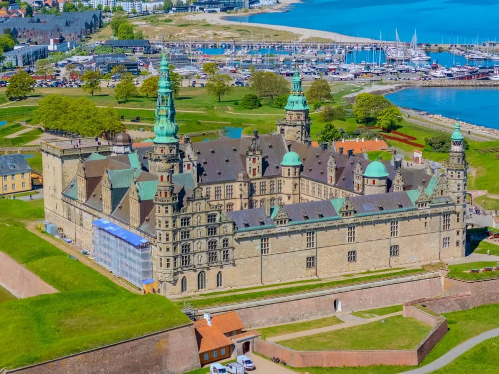 Kronborg Castle rising above the Øresund strait at dawn, Sweden visible on the far shore