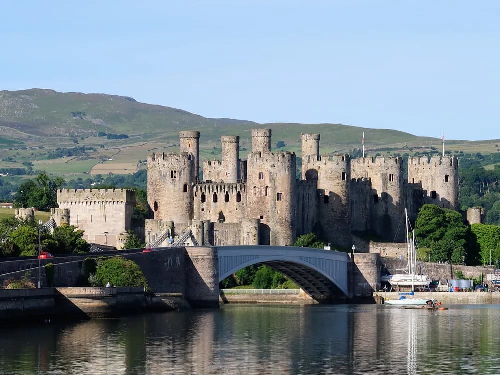 Caernarfon Castle and its medieval walls reflected in the harbour, Wales