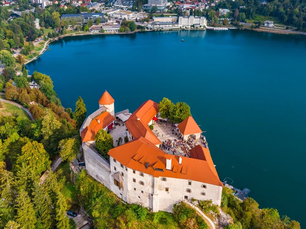 Bled Castle on its 130-metre cliff above Lake Bled with the island church in the foreground, Slovenia