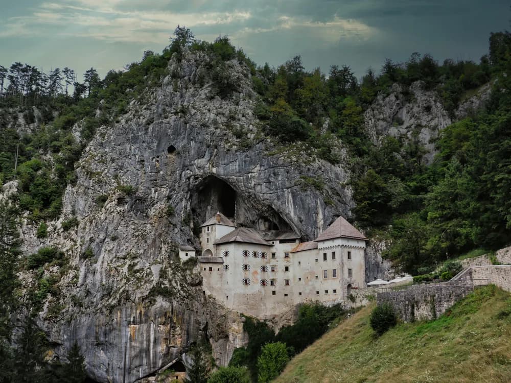 Predjama Castle built into the mouth of a cave in the vertical limestone cliff face