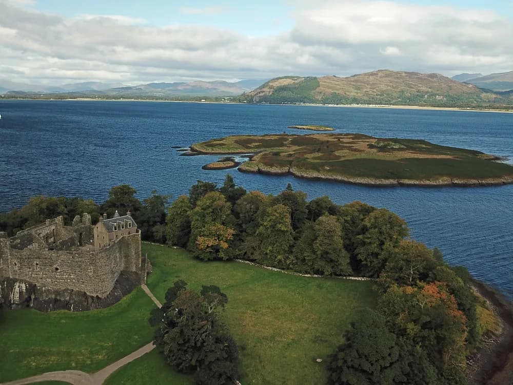 Kilchurn Castle ruins on its headland at the head of Loch Awe in Argyll, Scotland — viewed from the shore on the Oban circuit tour