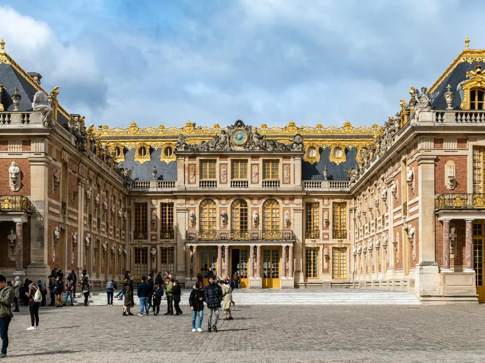 The Palace of Versailles garden facade reflected in the ornamental canal at golden hour