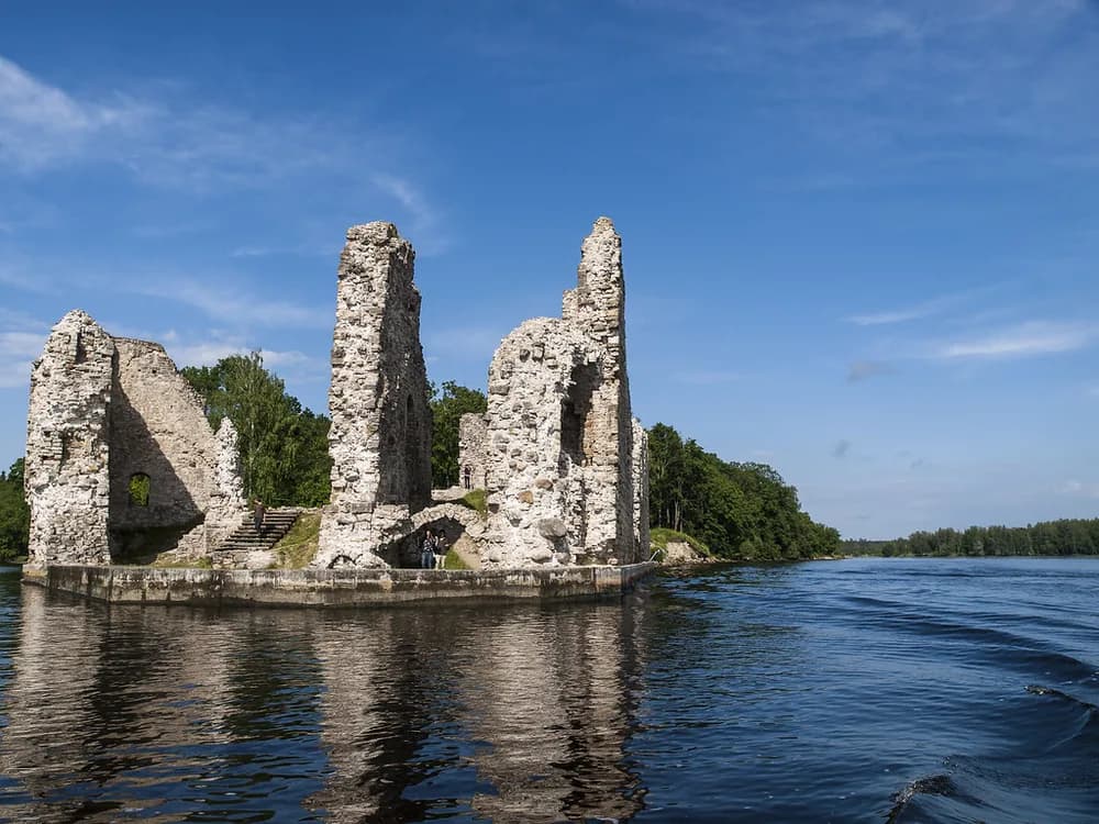 Koknese Castle ruins at the confluence of the Daugava and Pērse rivers in Latvia, medieval walls rising above the river confluence