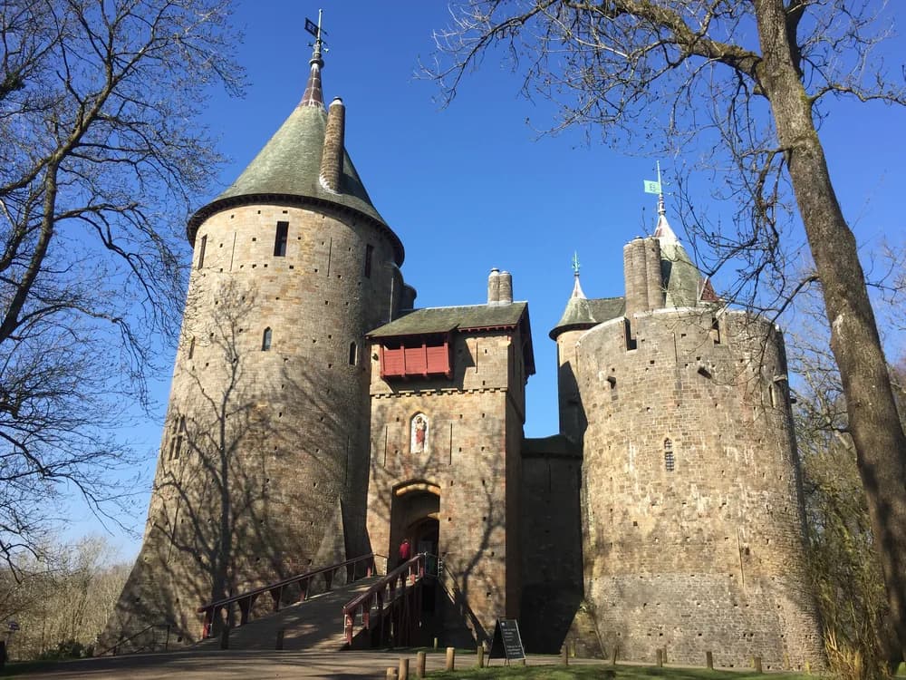 Castell Coch in Tongwynlais near Cardiff, Wales — the three conical-roofed round towers of William Burges's Victorian Gothic Revival reconstruction rising from the wooded hillside above the Taff valley