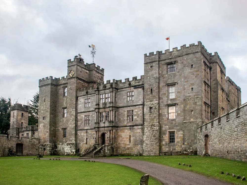 Chillingham Castle in Northumberland, England — the medieval Border fortress in the Till valley, now restored and operating as a heritage attraction with a ghost tour programme and the ancient wild white cattle herd in its surrounding park