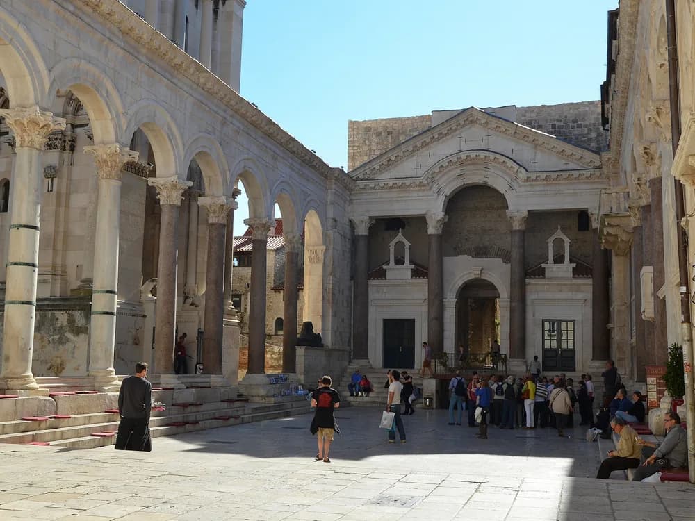 Diocletian's Palace in Split, Croatia — the Peristyle courtyard at the heart of the Roman imperial complex, with medieval buildings between the original Roman columns and the Cathedral of Saint Domnius beyond