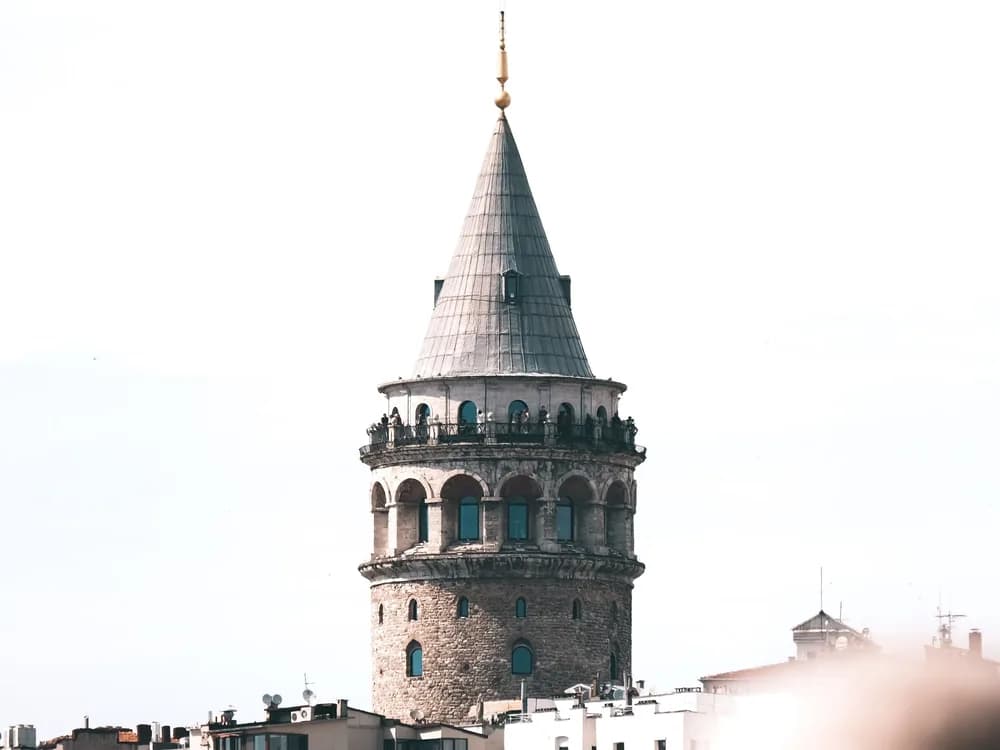 Galata Tower rising above the Beyoğlu skyline in Istanbul — the 14th-century Genoese watchtower on the Golden Horn, with the Bosphorus and Topkapı Peninsula beyond