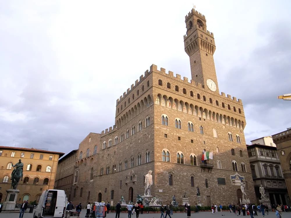 Palazzo Vecchio on Piazza della Signoria in Florence — the 1299 Gothic civic fortress with its asymmetric 94-metre Torre di Arnolfo, seat of the Florentine Republic and later the Medici Duchy, still Florence's city hall