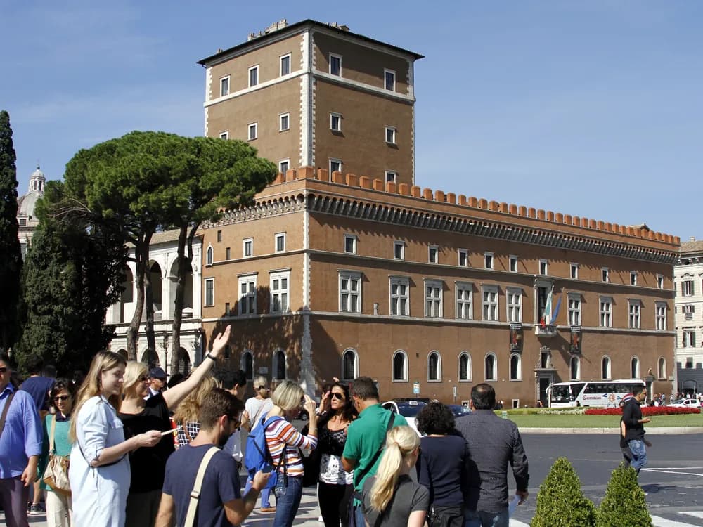 Palazzo Venezia on Piazza Venezia in Rome — the 15th-century papal palace and Mussolini's seat of government, with the Vittoriano Monument adjacent and the Capitoline Hill behind