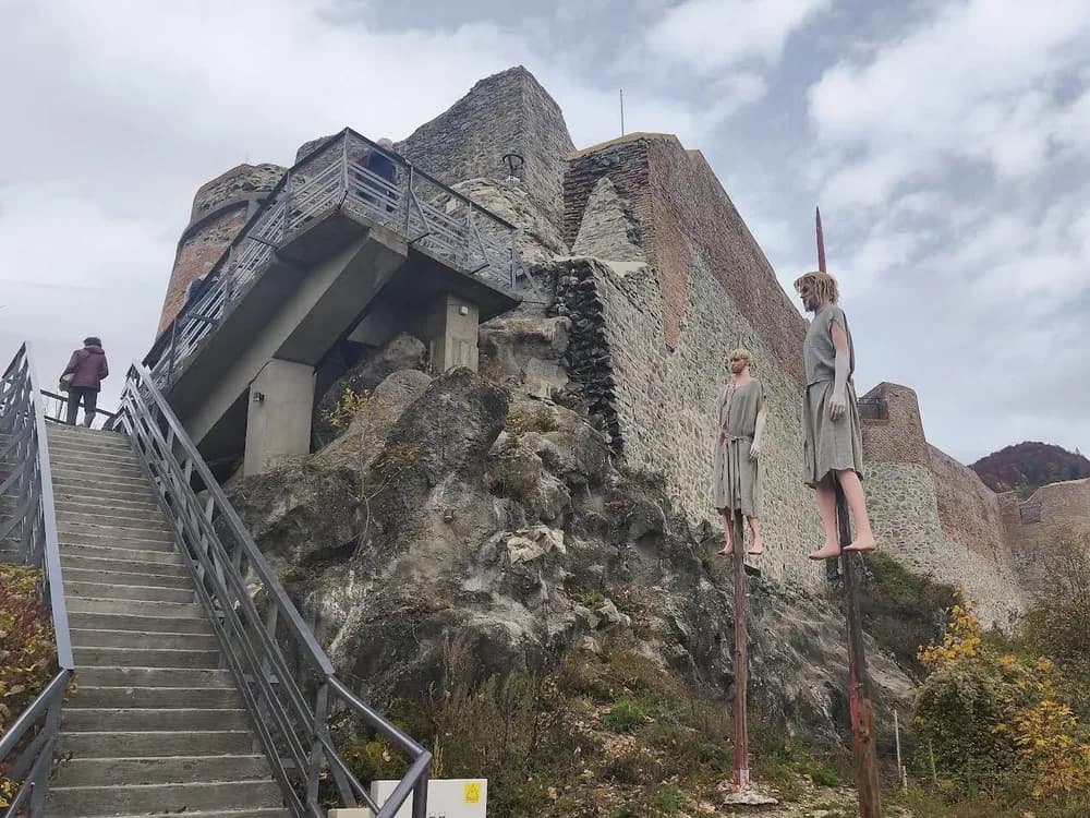 Poenari Castle ruins on the limestone crag above the Argeș River gorge, reached by 1,480 steps from the Transfăgărășan road below — Vlad the Impaler's cliff-top fortress in Argeș County, Romania