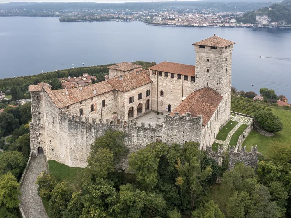 Rocca di Angera rising above Lake Maggiore — the Borromeo family's medieval fortress with 14th-century frescoes and panoramic views over the lake toward the Borromean Islands