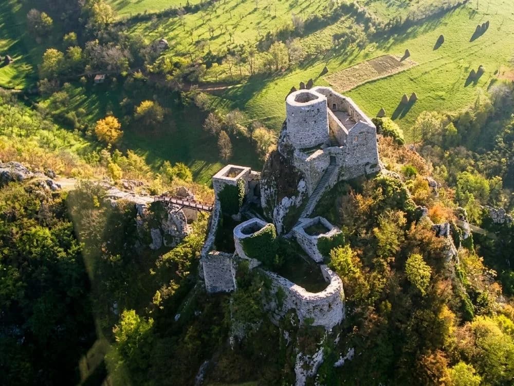 Vranduk Fortress on its limestone spur above the Bosna River gorge in north-central Bosnia, medieval walls rising from the canyon edge