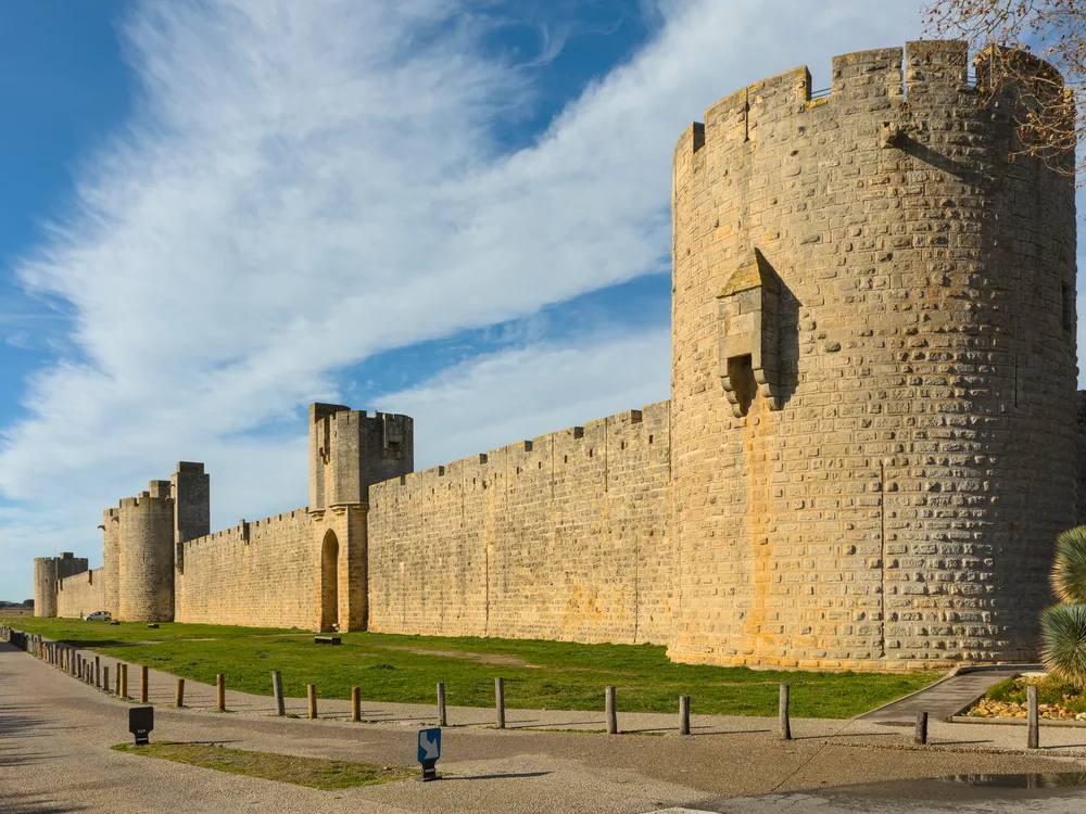 The medieval ramparts and Tour de Constance of Aigues-Mortes rising from the Camargue marshes — Saint Louis's 13th-century Crusade port and Huguenot prison, with nearly a mile of walkable medieval walls