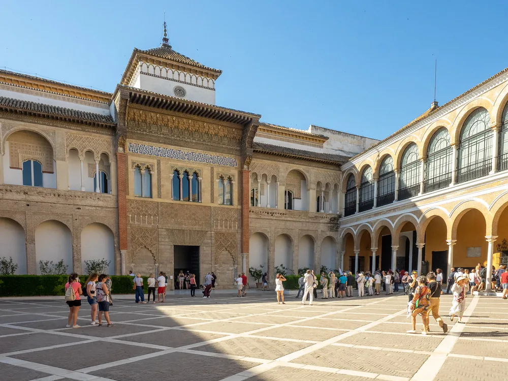 The courtyard of the Alcázar of Seville with its Mudéjar arches and reflecting pool, surrounded by orange trees