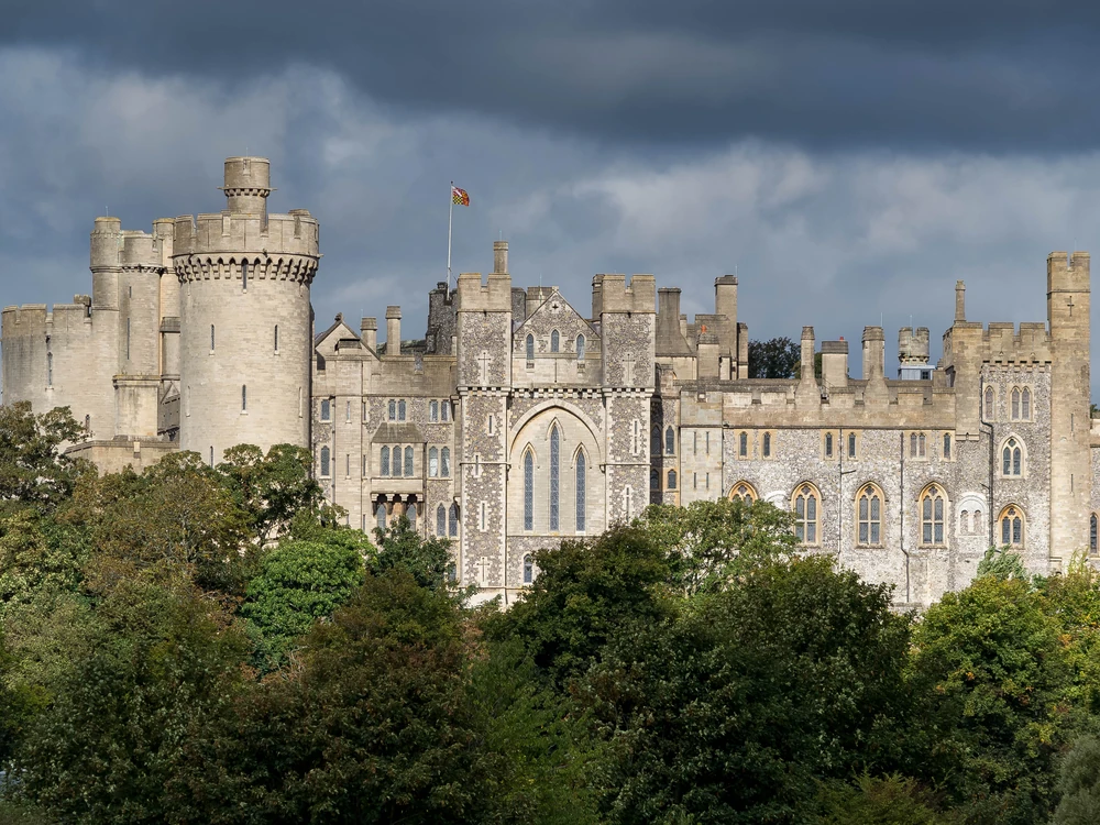 Arundel Castle's Gothic Revival towers and Norman motte rising dramatically above the River Arun valley in West Sussex on a clear autumn day