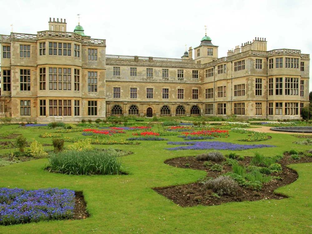 Audley End House north facade viewed across the Capability Brown landscape with the serpentine lake and Robert Adam bridge in the foreground
