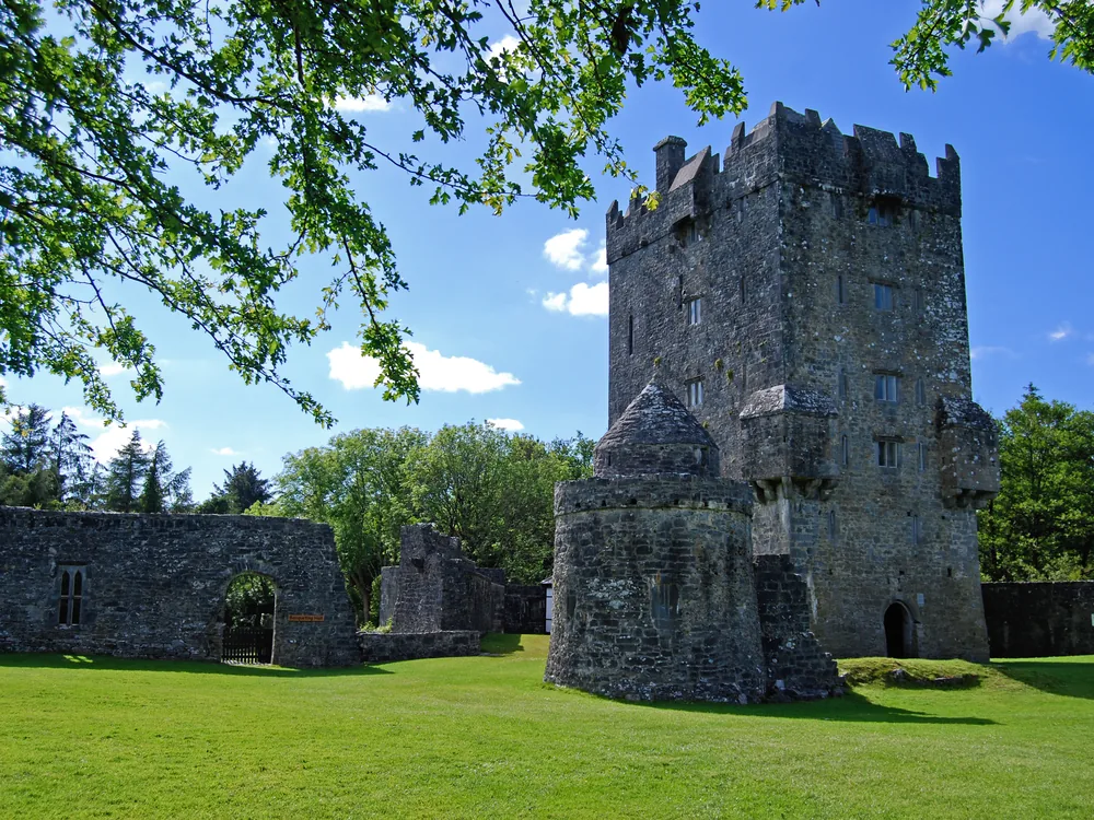 Aughnanure Castle on its rocky Lough Corrib promontory near Oughterard, County Galway, Ireland — the six-storey O'Flaherty tower house above the River Drimneen with Connemara mountain backdrop