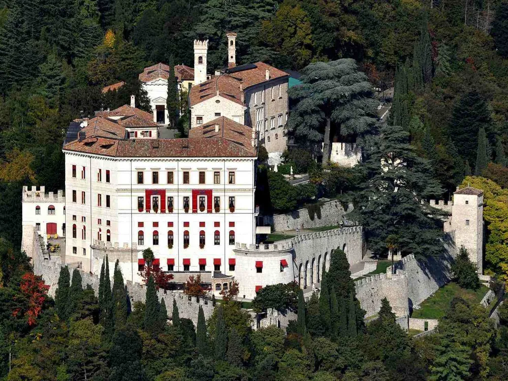 CastelBrando rising above Cison di Valmarino, the medieval castle complex surrounded by the stepped Prosecco Hill vineyards of the Conegliano Valdobbiadene UNESCO landscape in the Veneto