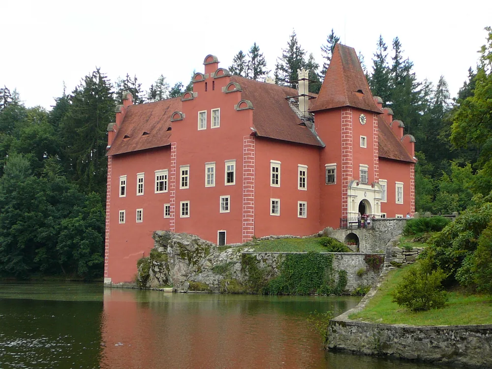 Červená Lhota Castle reflected in its pond — the red Renaissance water castle on a rock island in South Bohemia, one of the Czech Republic's most photographed historic sites
