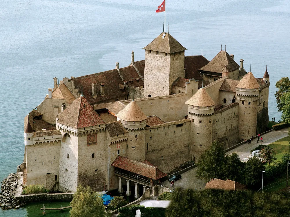 Château de Chillon rising from Lake Geneva with the Swiss Alps reflected in the still water