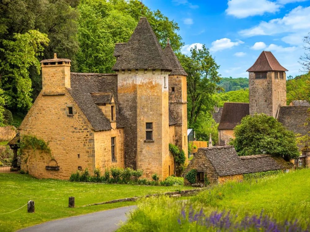 Château de Lacypierre — the family-restored Périgord Noir manor château at Saint-Crépin-et-Carlucet, Dordogne, France, with its characteristic steep slate roofs and local limestone walls
