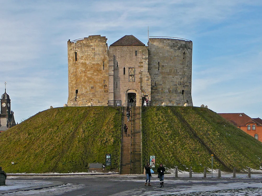Clifford's Tower quatrefoil keep on its Norman motte in York city centre — the largest surviving element of York Castle, site of the 1190 York Massacre, restored 2022 with a new roof deck