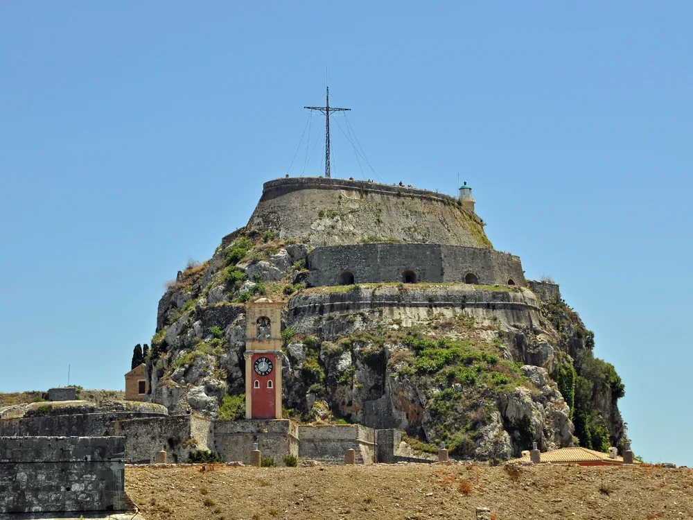 Old Fortress of Corfu (Palaio Frourio) on its double-peaked rocky promontory, with the Venetian inner harbour and sea channel visible from Corfu Town