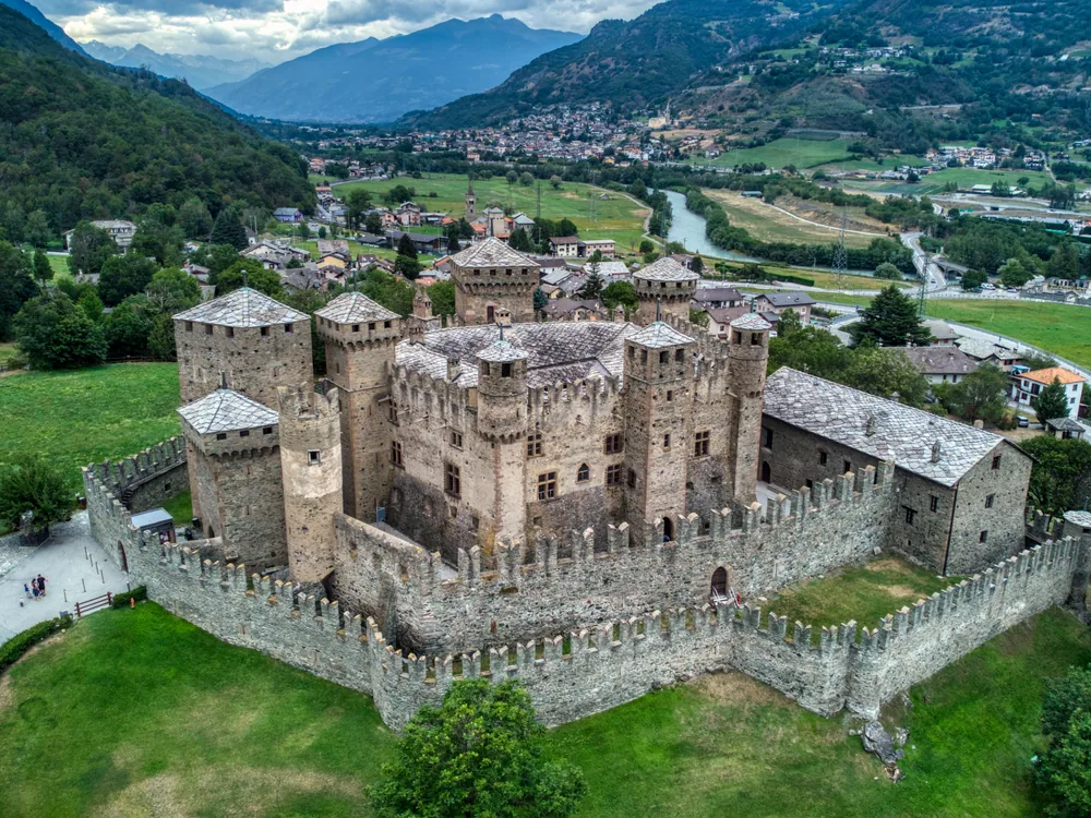 Fénis Castle in the Aosta Valley, Italy — the Challant family's pentagonal castle with a frescoed courtyard and semicircular external staircase