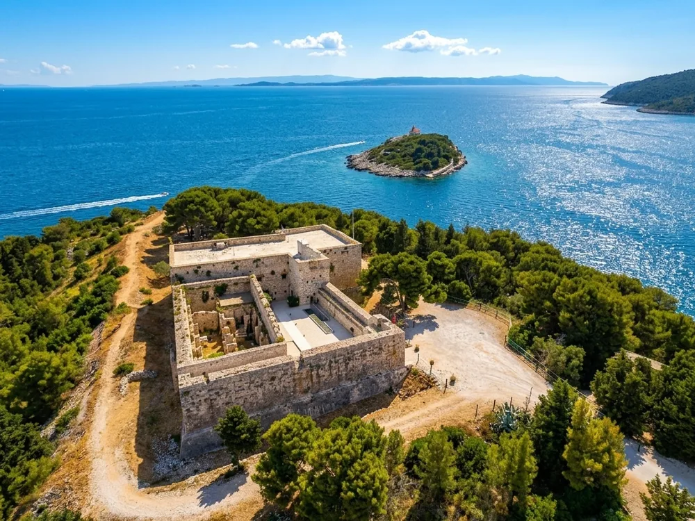 Fort George on Vis Island, Croatia — the British Napoleonic-era limestone hilltop fortress above Vis Town and harbour, built during the Royal Navy's occupation of the island 1811–1815, with views over the Adriatic